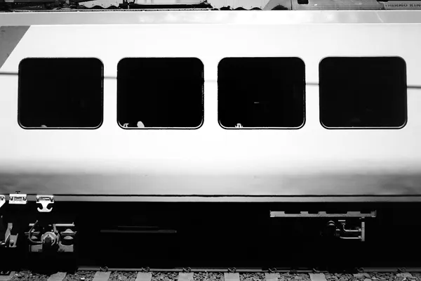 A side-on photograph of the exterior of a Melbourne train carriage, showing a sequence of four square black windows.