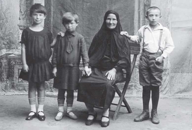 A formal photograph of two young girls, an older lady, and a young boy. From left to right: Ethel, Pesha, Rose, and Freika.