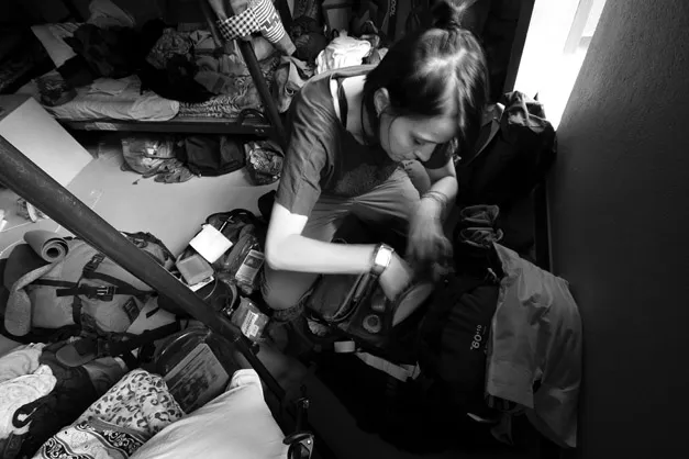 Figure 1.2 Photograph of myself packing, situated amongst six people’s belongings intermingled on the floor of a hostel dormitory room in Nepal