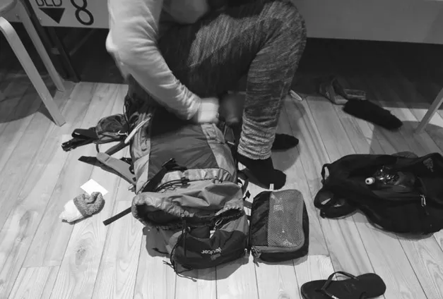 Figure 1.3 A tourist sitting on their backpack while trying to close the zip