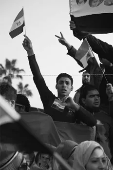 Figure 1.1 A man waves an Egyptian flag in Tahrir Square hours before President Mubarak steps down from office on 11 February 2011