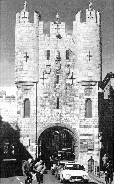 1.1 Mícklegate Bar, York York's rich history goes back over 1,900 years to the founding of the Roman fort of Eboracum in ad 71-74. The Roman defences surrounding the legionary fortress and the colonia were strengthened and heightened by each successive group of invaders—Angles, Vikings and Normans—until they achieved their present form during the thirteenth and fourteenth centuries. No other English city has such a remarkable set of walls, towers and bars. Micklegate was the Viking 'great street', the principal highway from the south and west that curved down the hill to the commercial heart of Joruik. Until 1863 the Ouse could be crossed only this way. Micklegate Bar preserves its Norman arch, but the upper parts were redesigned in the fourteenth century. Until the late 1820s the entrance was protected by a barbican, which stretched about as far as the front car in the photograph. Micklegate Bar was the scene of ceremonial receptions and the place where the heads of executed traitors were displayed on many occasions in the Middle Ages.