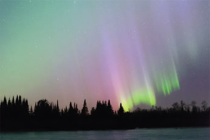 15.2 The shimmering lights of the Aurora Borealis have mesmerized people for generations. Here, intense curtains of light descend upon the shoreline of a frozen lake in northern Minnesota.