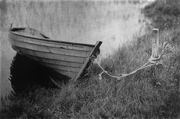 Figure 1.5. Boat, Scottish Loch, monochrome gum bichromate © Johnny Brian 2014. Brian’s photograph is poignant for several reasons. One, it is photographed in Scotland, birthplace of Mungo Ponton who made the first dichromate photograms in 1839. Two, it is a monochrome gum similar to those that would have been created at gum’s dawning, although Brian printed his monochrome gum in multiple layers, a technique that wasn’t discovered until decades later. Three, it references a very famous image by Peter Henry Emerson, Gathering Water Lilies (1886), but Brian’s boat is empty of people and his somewhat-Pictorialist-romantic aesthetic has a contemporary melancholy which is so prevalent today.