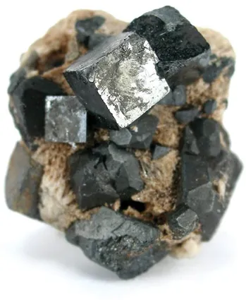 A photograph of naturally occurring perovskite crystal. The crystals adopt a cubic shape.