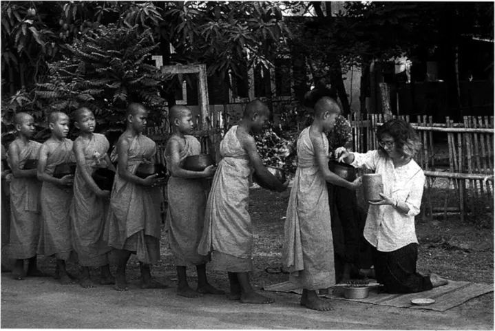Plate 1.3: Author earns merit feeding novice monks.