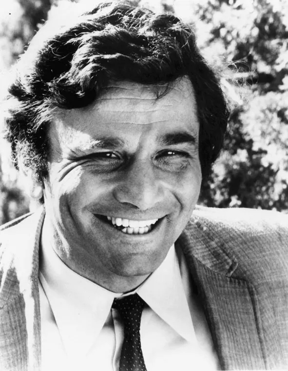 The black and white photo shows Peter Falk as a youthful 46 years of age from the shoulders up. He wears a sports jacket, bottom-down white shirt, and thin polka dot tie with full-leafed trees in the background. His expression has a genuine crinkle-eyed and unrestrained, full-dentured smile, like a boy who has done some mischief. 
