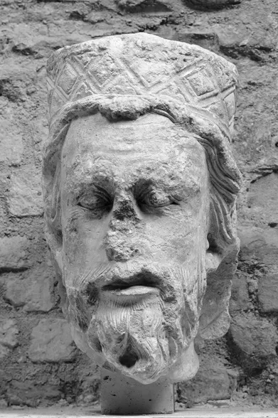 A battered, sculpted head of a king.