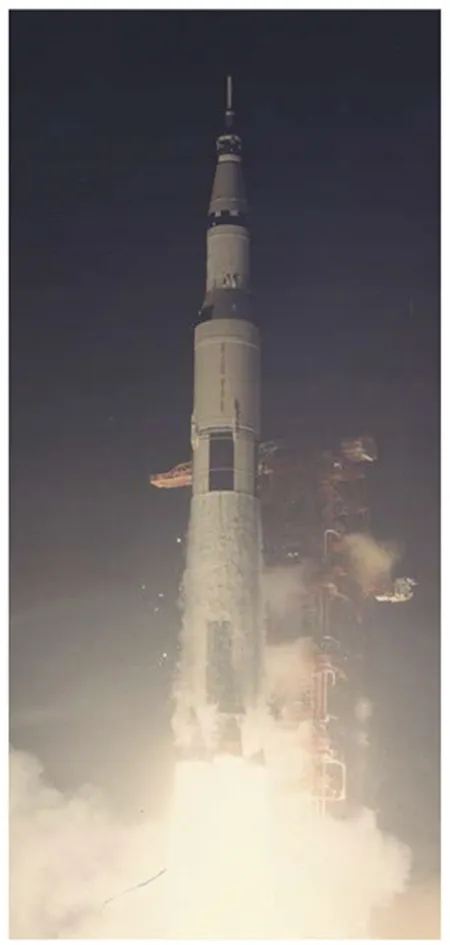 The spacecraft prepares for liftoff against a dark sky as clouds of smoke and fire issue from its engines.