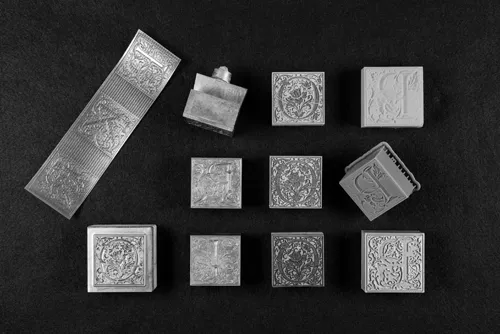 Letterpress Type. From Right Column, Top to Bottom: Goudy Cloister Initials Relief Type in Photopolymer; Photo-Etched Magnesium; Modern Lead-Alloy Cast from Original Brass Matrices; Laser-Engraved Maple Wood; Stereolithographic Plastic; Fused Deposition Model 3D Print. Photograph by Jiageng Lin.