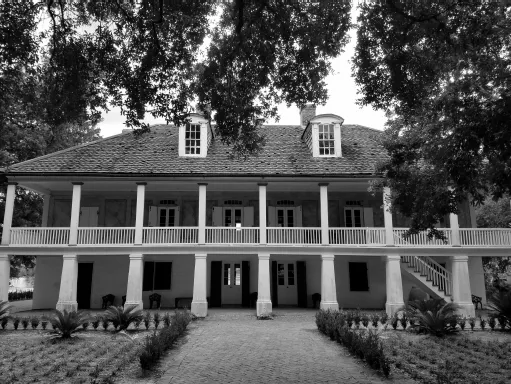 A photo shows the front facade of a two-story house on Whitney Plantation.