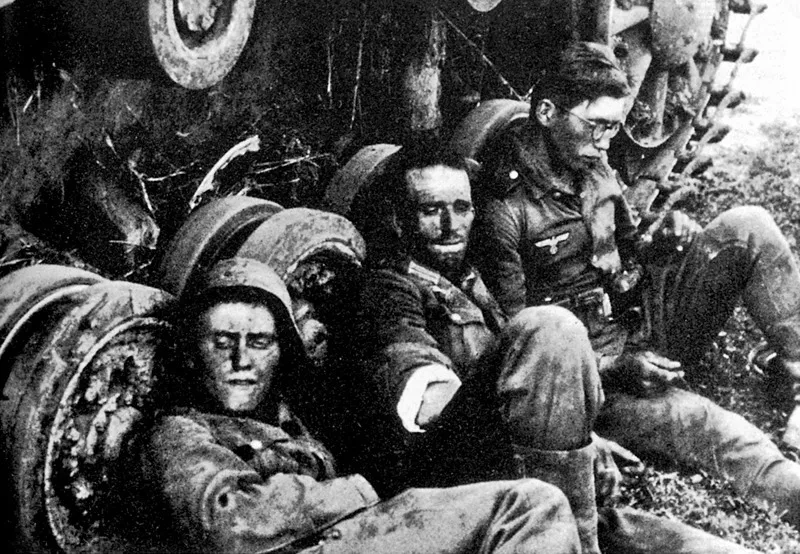Estate 1941: soldati tedeschi stanchi della battaglia si riposano appoggiati a un carro armato.