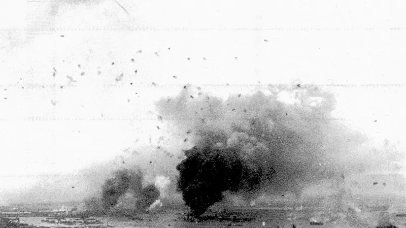 Pearl Harbour, 7 dicembre 1941. Il fumo si leva dalle navi da guerra americane colpite, mentre in cielo esplodono i proiettili dell’antiaerea americana.