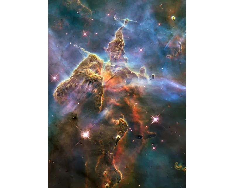 IL NOSTRO MAGNIFICO UNIVERSO. Una colonna di gas interstellare e polveri all’interno della nebulosa della Carena. Un’immagine a colori, differenti a seconda dei vari gas. © NASA, ESA, and M. Livio and the Hubble 20th Anniversary Team (STScI).