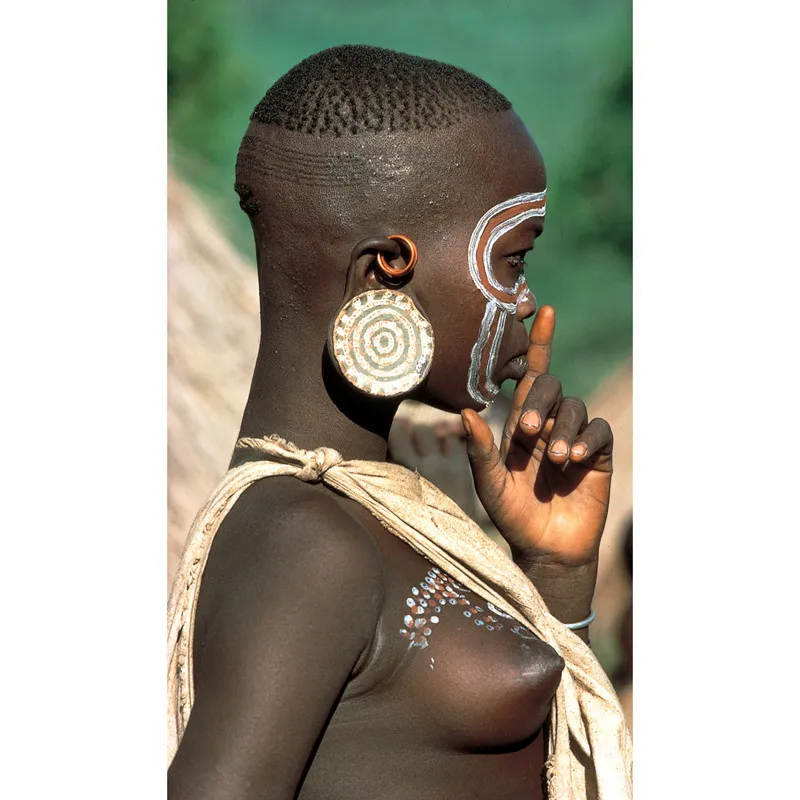 Le orecchie femminili sono state maltrattate in varie culture del mondo, che ne hanno forato, allungato e decorato i lobi in centinaia di modi. In origine ciò mirava a rendere la donna più saggia o a proteggerla dalla sfortuna, oggi viene praticato soprattutto per motivi estetici. © Robert Estall Photo Library/Carol Beckwith/Angela Fisher 