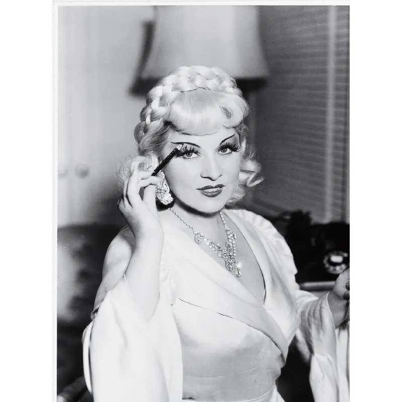 Le sopracciglia femminili, meno folte di quelle maschili, vengono spesso ulteriormente assottigliate per renderle ancora più sensuali, come si nota in questa foto di Mae West. © AKG Images