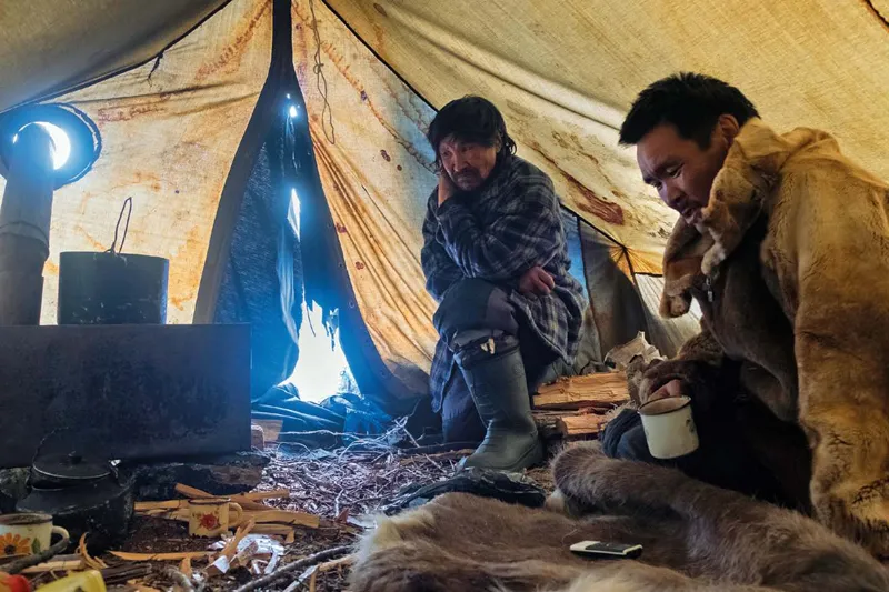 Vova nella tenda di Miša, il pastore di turno. Gli allevatori di renne di Magadan passano l’inverno nelle tende di tela, dotati di una piccola stufa di metallo e pelli di renna, con cui coprono il terreno.