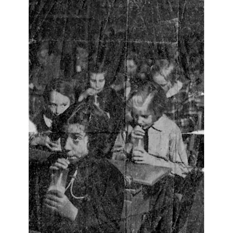 La bambina in primo piano è Clara, la sorella di Selma. La foto pubblicata sul giornale era accompagnata dalla seguente didascalia: «Questa sì che è una novità: il latte con la cannuccia. Basta guardare le espressioni delle scolare per capire se è di loro gradimento…» (24 gennaio 1939).