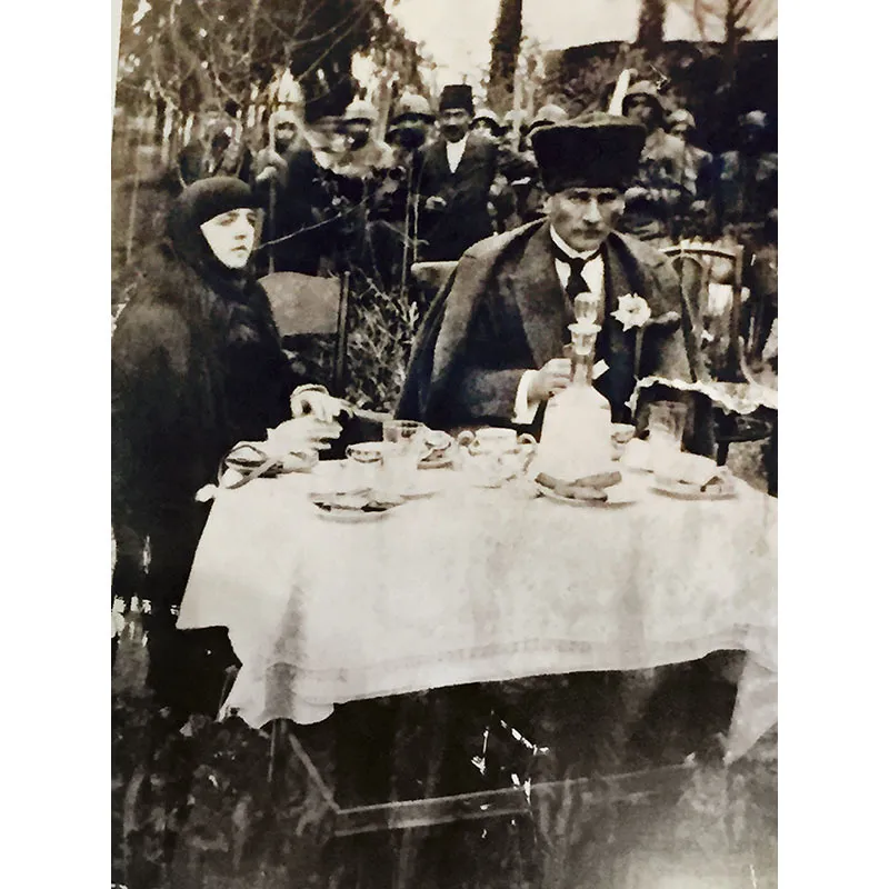 12. Questa è la foto di una grande immagine affissa alla parete di un noto ristorante alla moda. Ritrae Kemal Atatürk (1881-1938), padre della Turchia moderna, con sua moglie. Sullo sfondo alcune truppe. La donna ha il capo coperto dal velo secondo la regola musulmana; il presidente Atatürk calza il copricapo di astrakan al quale era particolarmente affezionato. Tra le numerose innovazioni da lui introdotte, ci fu il divieto per gli uomini di mettere il fez rosso simbolo di un paese che il presidente voleva profondamente innovare.