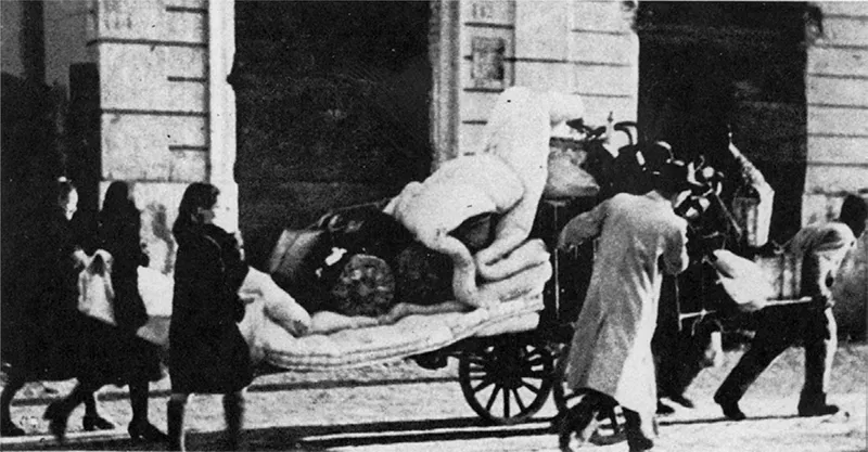 Una famiglia trasporta su un carretto le sue masserizie recuperate dopo un bombardamento.