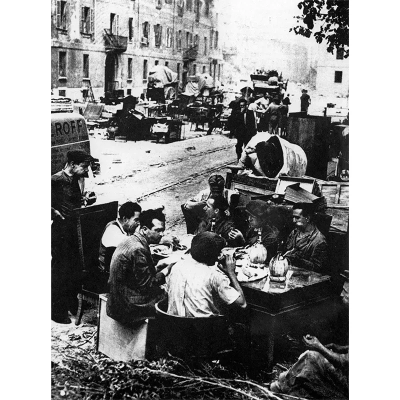 Una sosta dopo un bombardamento: prima di raccogliere le proprie cose, si mangia un boccone per la strada.