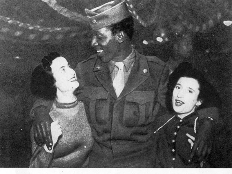 Prime immagini dell’Italia liberata. Un soldato di colore USA con due ragazze romane.