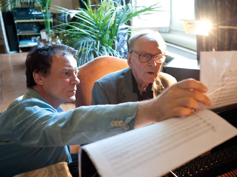 Due inimitabili maestri. Qui Ennio Morricone (qui stavamo lavorando al commento musicale dell’adattamento televisivo delle quattro commedie di Eduardo de Filippo: Filumena Marturano, Questi fantasmi, Napoli milionaria e Sabato, domenica e lunedì.); di seguito, a casa di Charles Aznavour, che proprio in questa occasione mi regalò una sua canzone.