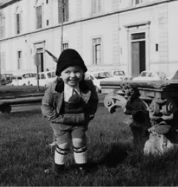 Foto di una bambina abbigliata con un vestito da maschio.