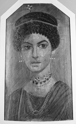 A portrait of a young woman from Hawara. She wears silver earrings and several elaborate necklaces. Her head is covered by a black cap decorated with bronze chains.