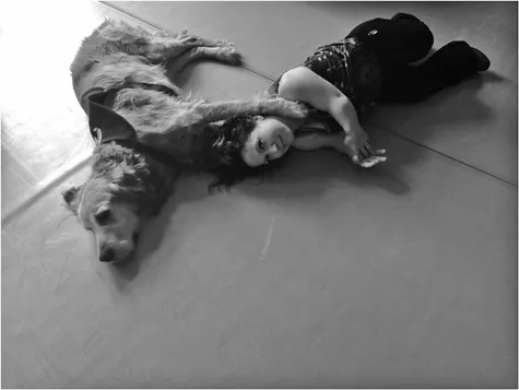 The disabled dancer Silke Schöenfleisch lies on the studio floor her head cradled in the paws of her helper dog Jack.