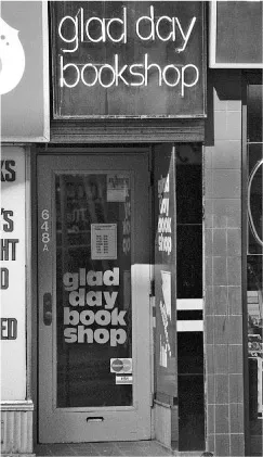 The storefront of the Glad Day Bookshop. The sign above the door is in neon lights and there is another sign on the front door which is glass that also says its name.