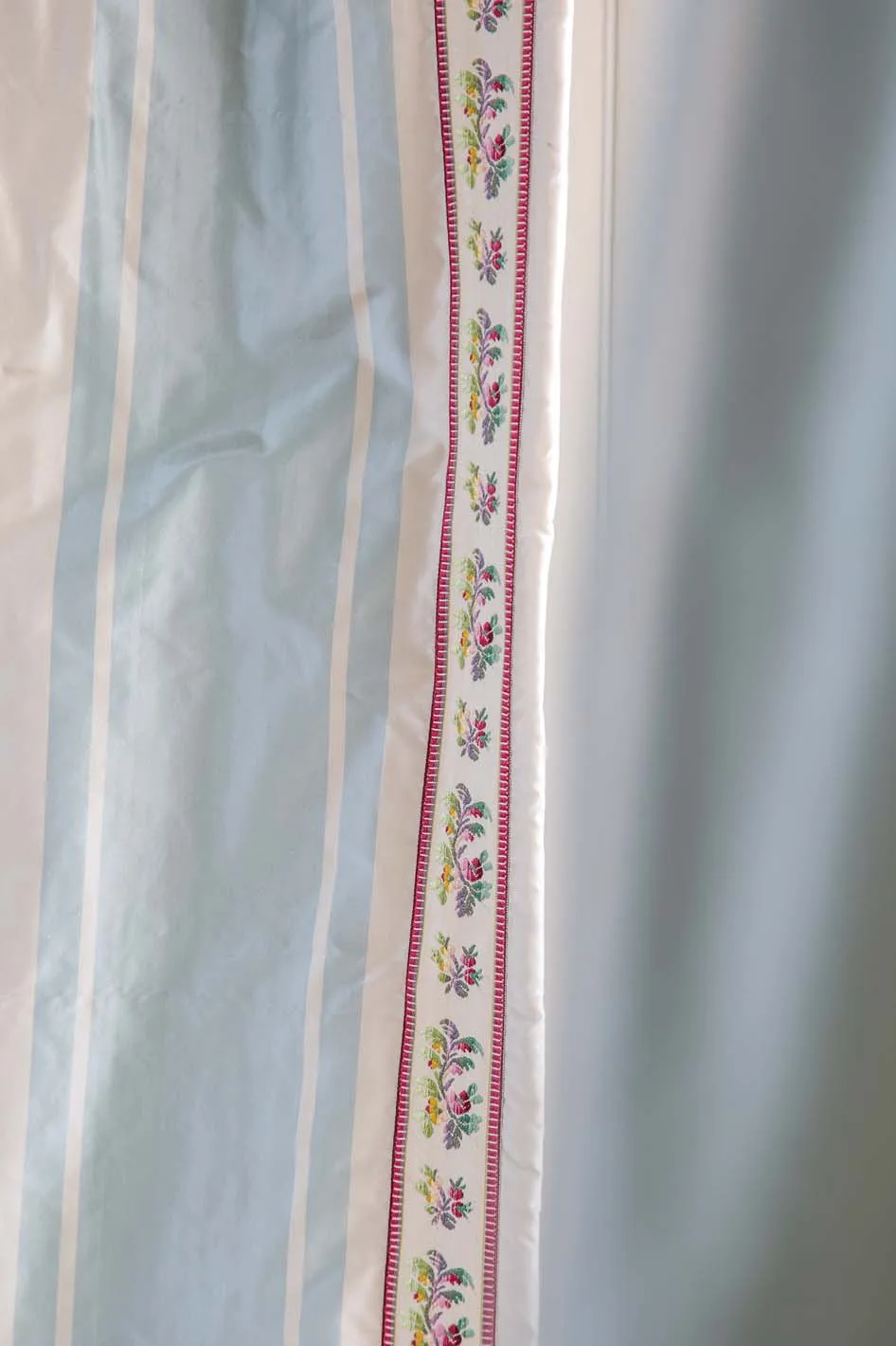A lined and interlined silk taffeta curtain is outlined with an applied tape trim for a deceptively simple elegance.