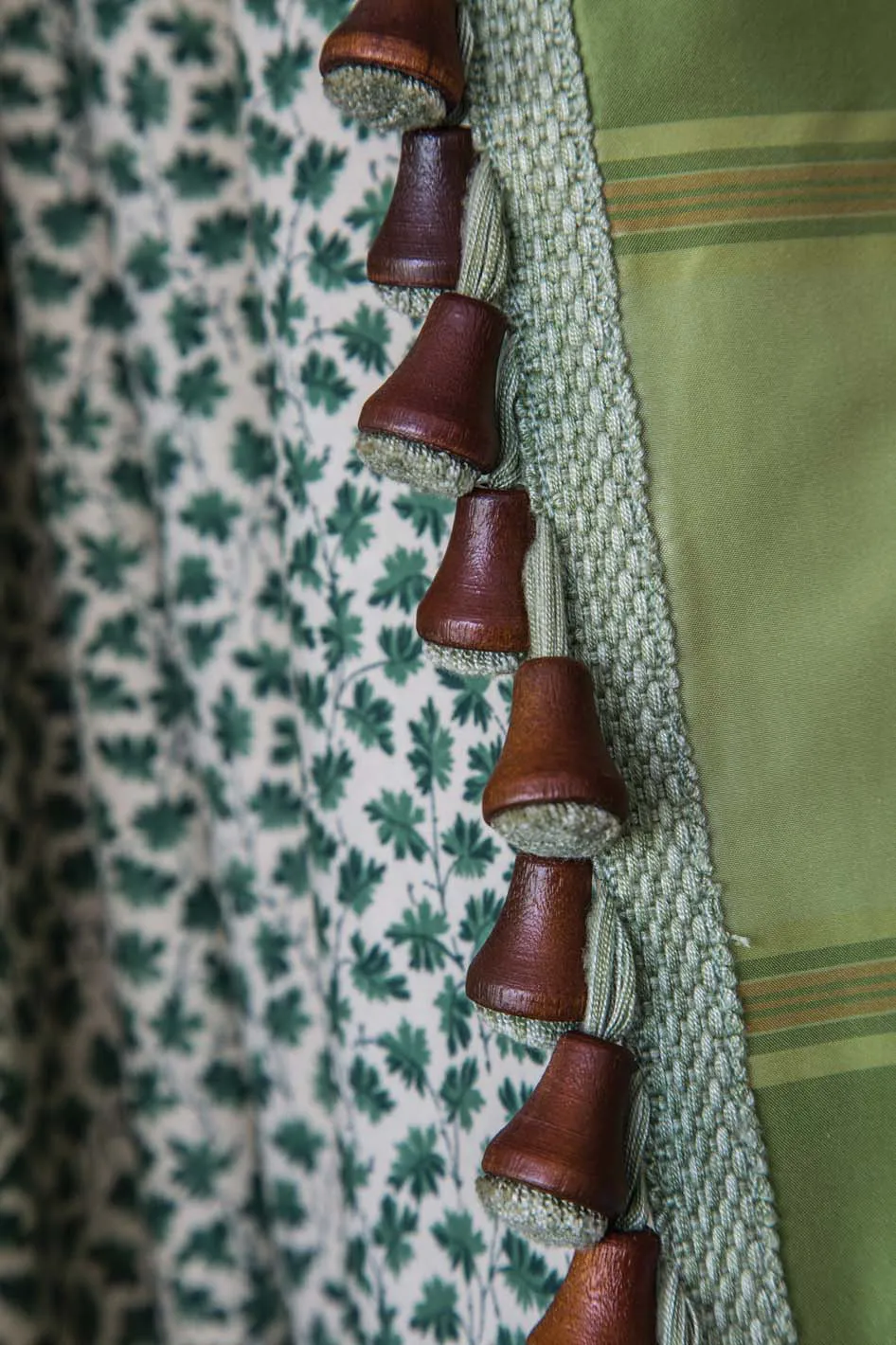 Attractive green and mahogany bell trim from Rogers Textiles was first painted by hand, then sent to the textile company to create this lovely, custom trim for just the right finishing touch on a portiere curtain.