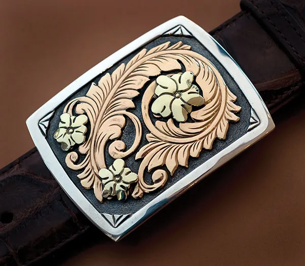 Photo of buckle with flower and leaves.