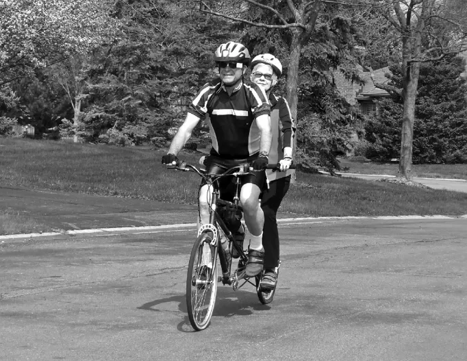 The photograph depicting two person riding on a bicycle.