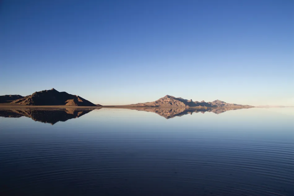 Photograph of a landscape consisting of two mountains and water.