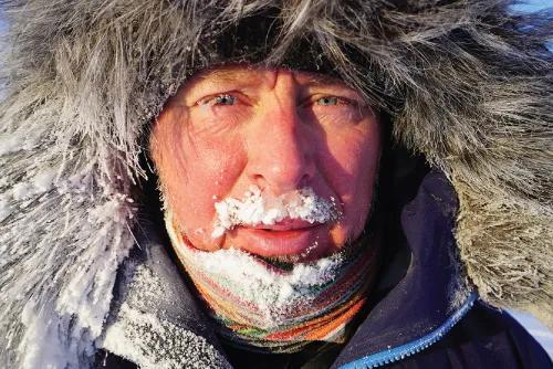 Photograph of a manâs face covered fully in woollen clothes.